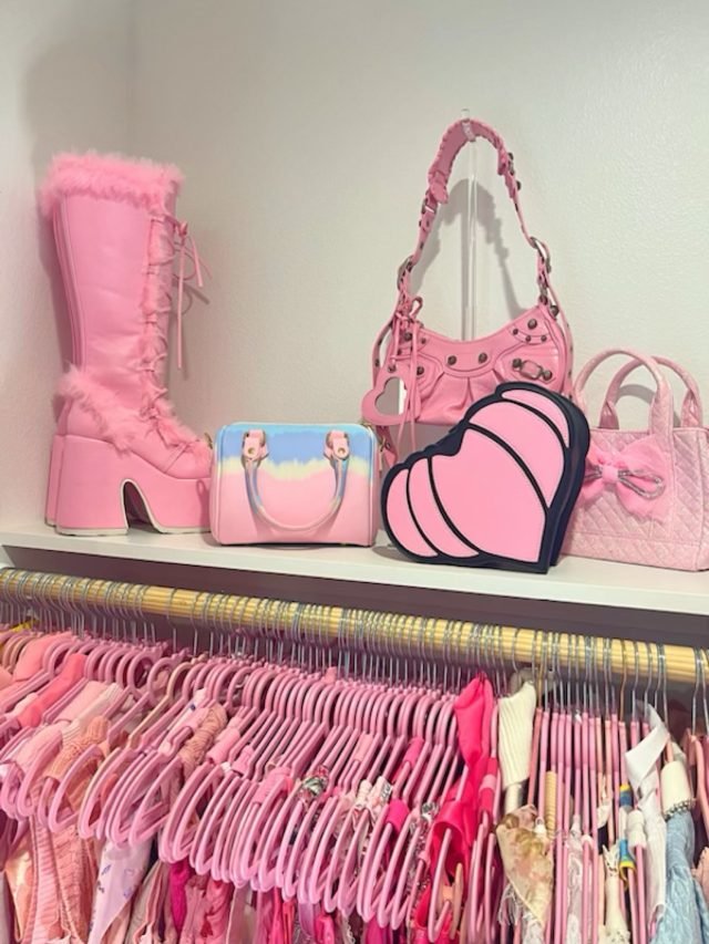 Pink platform boots and quilted handbags shelved above a row of hanging pink garments