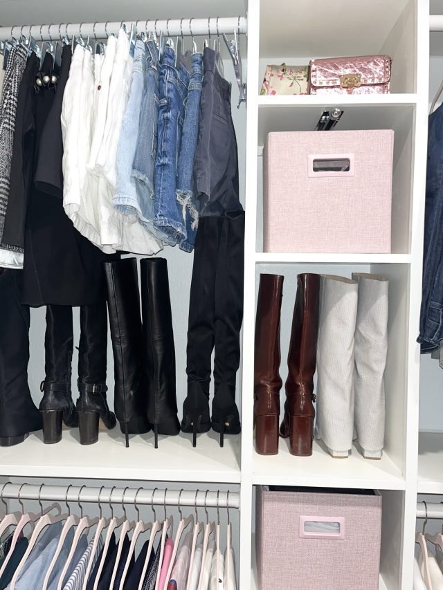 Boots stored upright on a lower shelf beside blouses and a pink storage bin