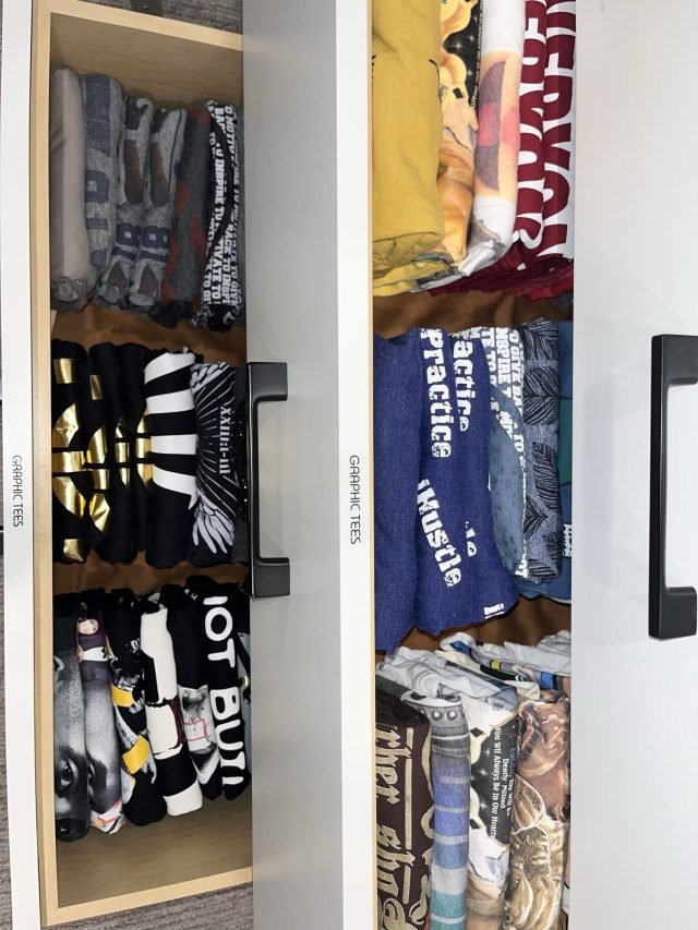 A child's closet with graphic tees hung and folded clothing shelved