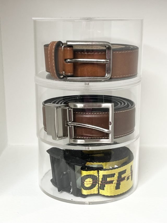 Leather belts coiled on a three-tier acrylic turntable