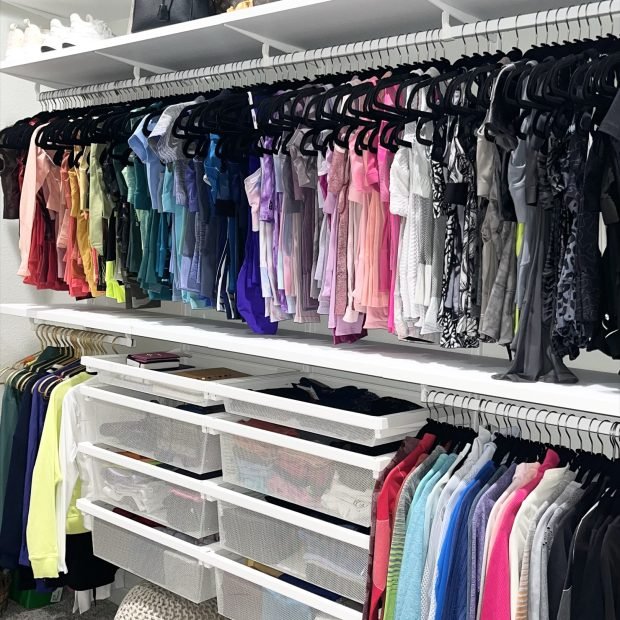 Activewear hung by color above clear drawers and a woven floor pouf
