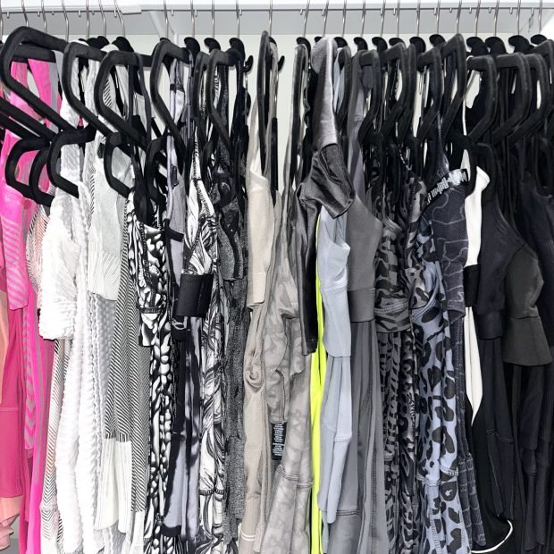 Evening dresses and gowns hung on black velvet hangers along one rod