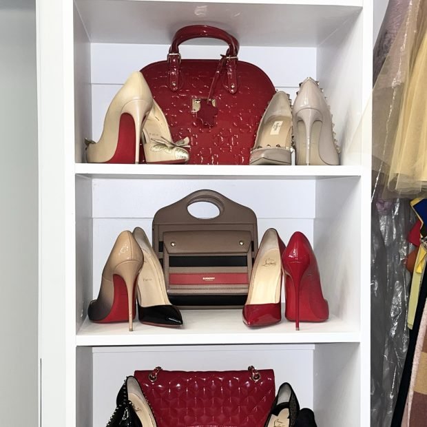 Designer heels and handbags displayed on white shelving