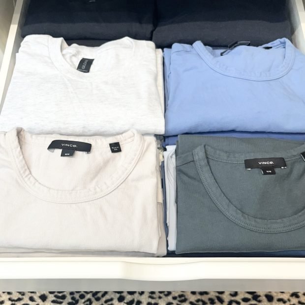 Folded sweaters and tees stacked in matched pairs on a closet shelf