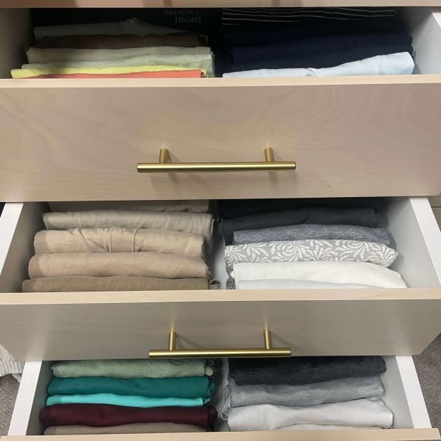 Closet drawer with precisely folded clothing separated into compartments