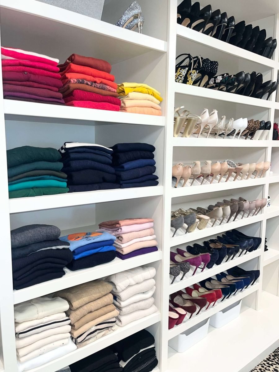 Folded clothing organized by category on walk-in closet shelves in a Dallas home
