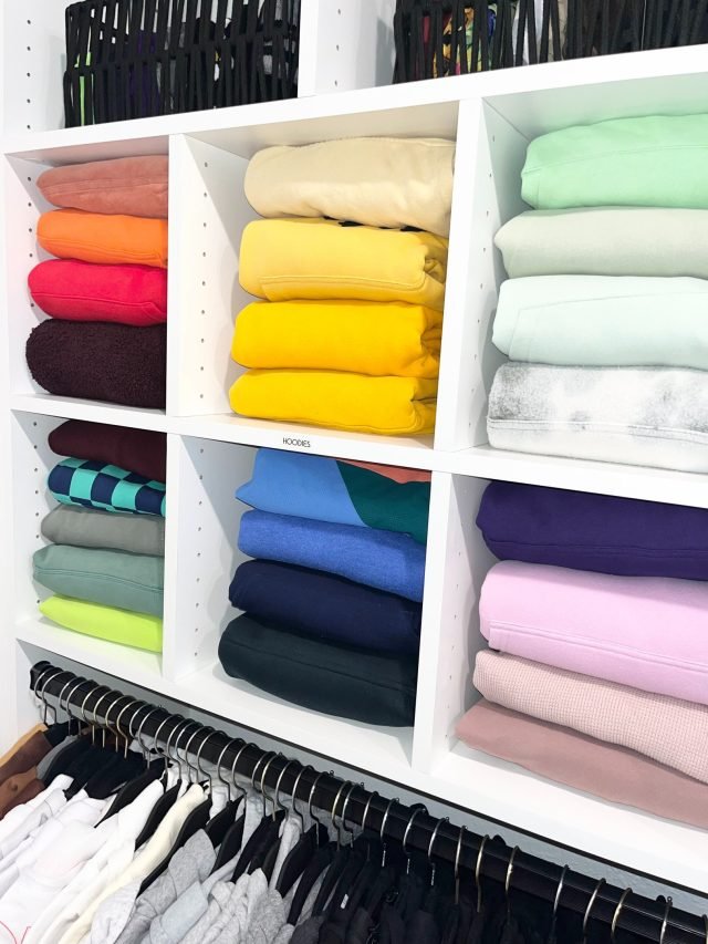 Folded clothing placed into a primary closet during a full home unpack