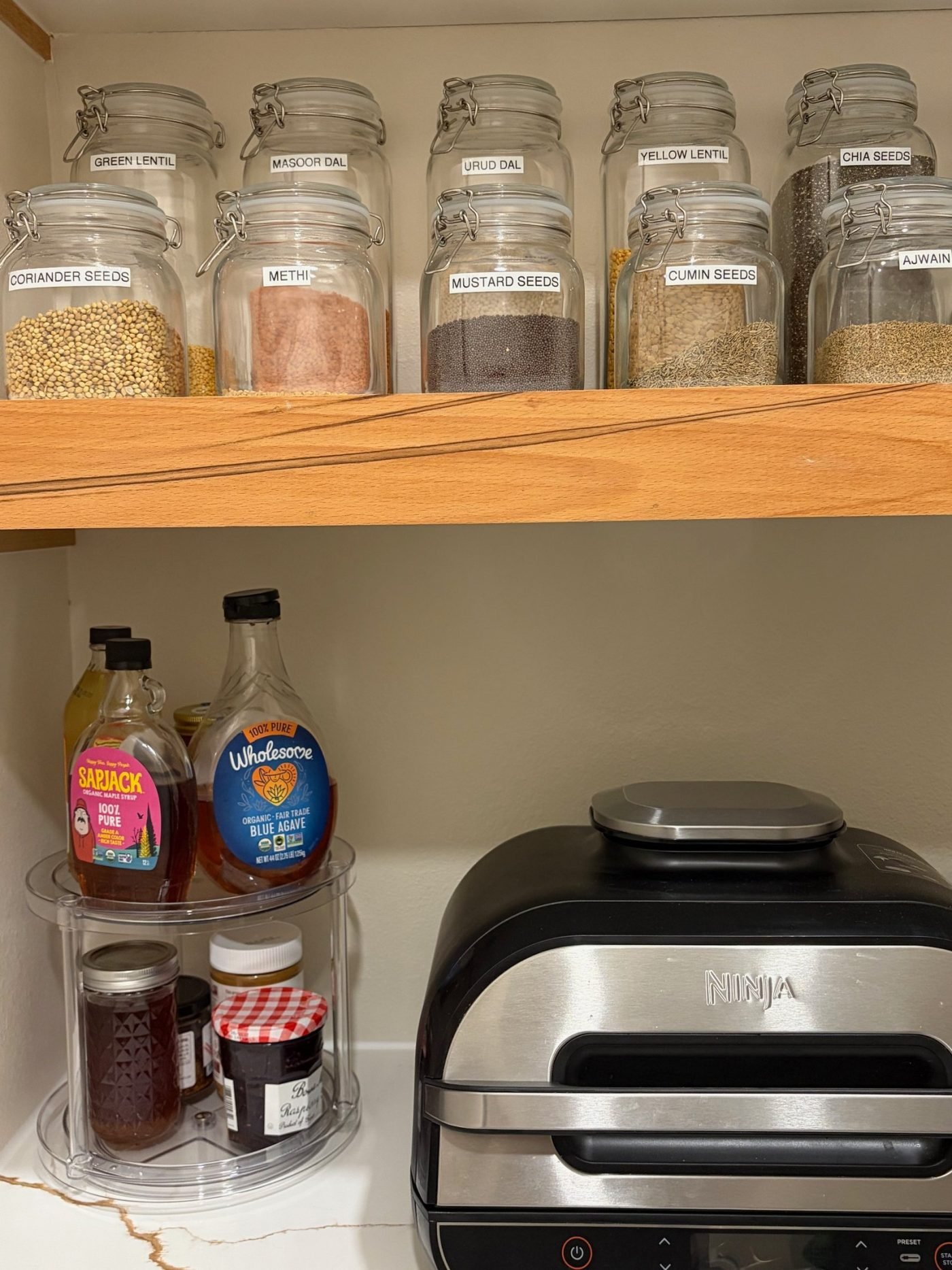 Kitchen spices decanted into labeled glass jars after a full home unpack