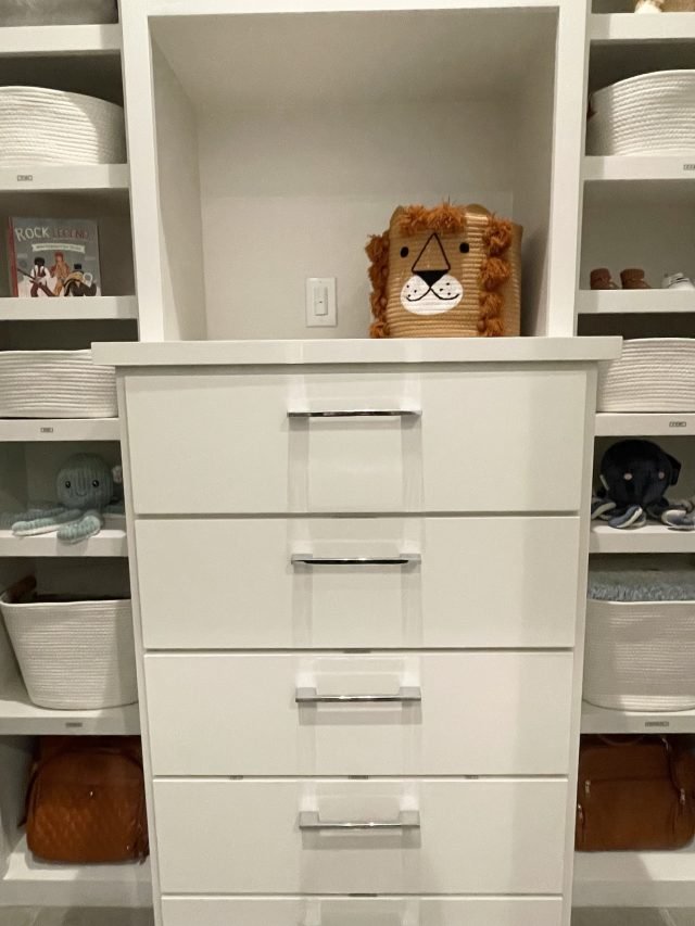 A nursery closet with a drawer tower, woven bins and shelved shoes
