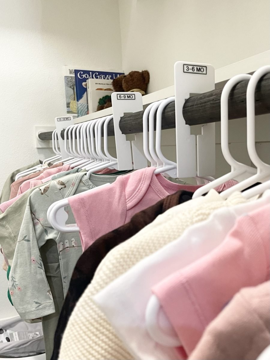 Baby clothes hung behind size dividers marked three to six months