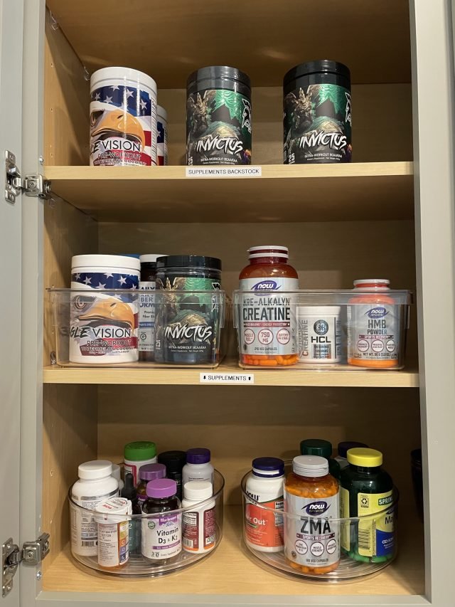 A cabinet of protein powders and vitamins on labeled turntables