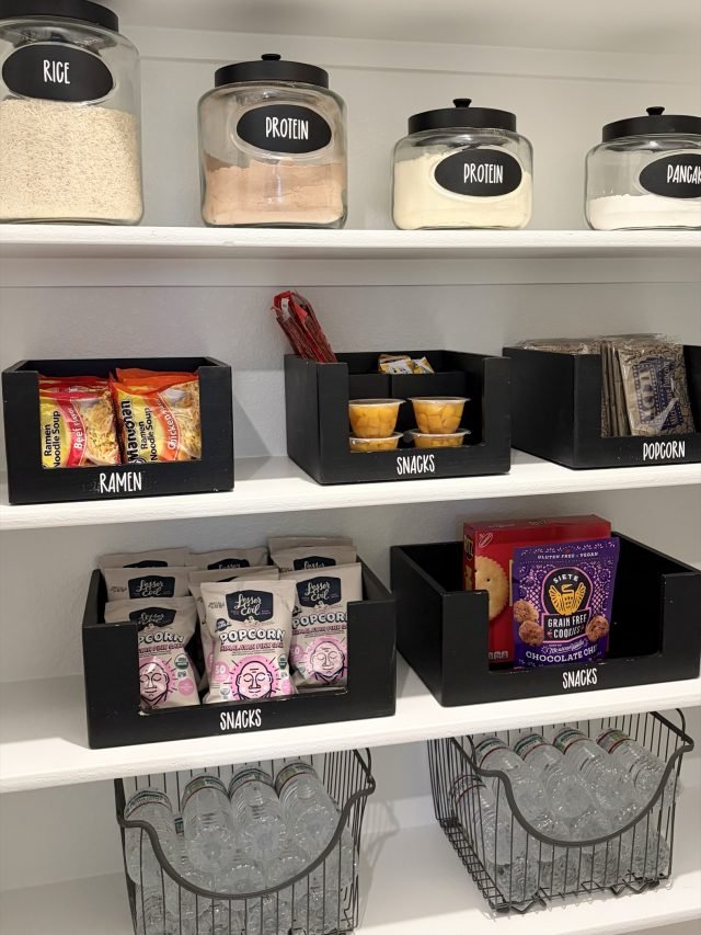 Labeled black bins for ramen, snacks and popcorn beneath glass canisters