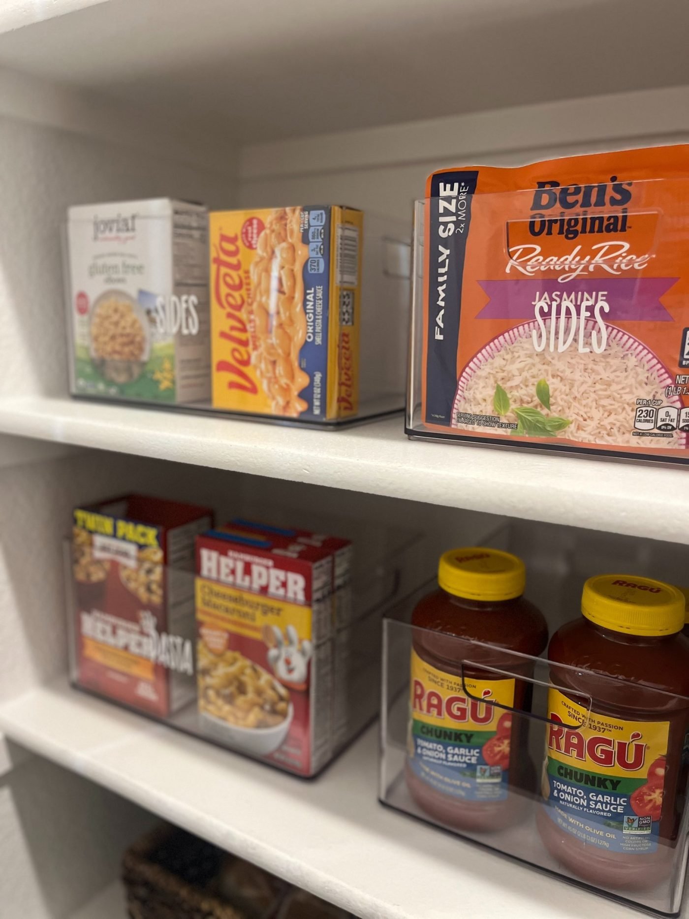 Pantry organized with labeled acrylic containers after a Plano relocation unpack