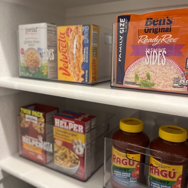 Pantry organized with labeled acrylic containers after a Plano relocation unpack