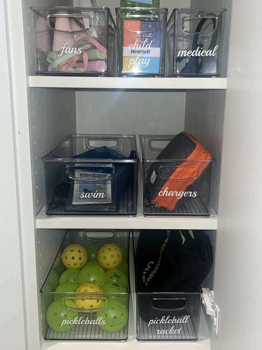 Clear closet bins labeled fans, swim, chargers and pickleballs