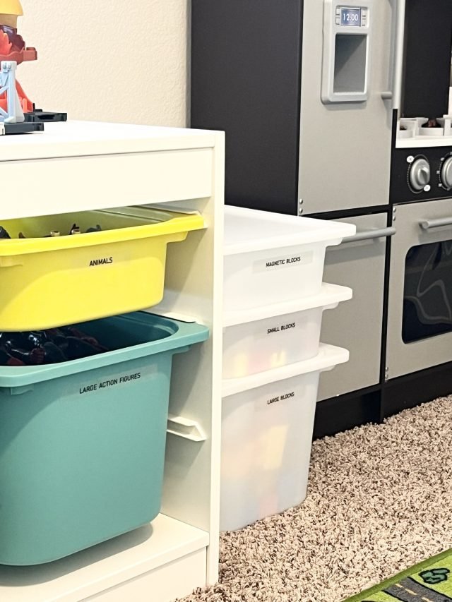 Playroom storage bins beside a toy kitchen and washer-dryer set