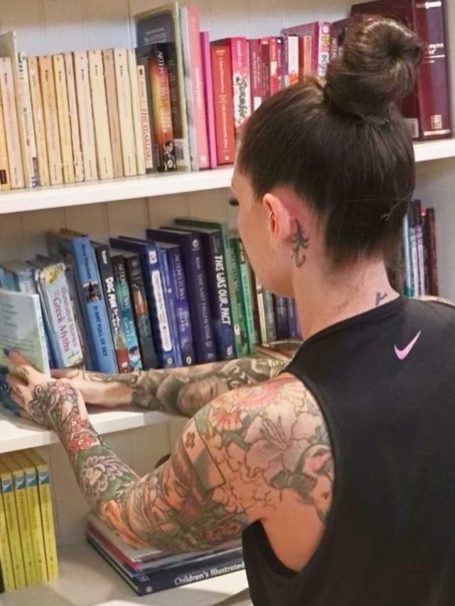 Ashley Matteson shelving books by size and color on a client's built-in